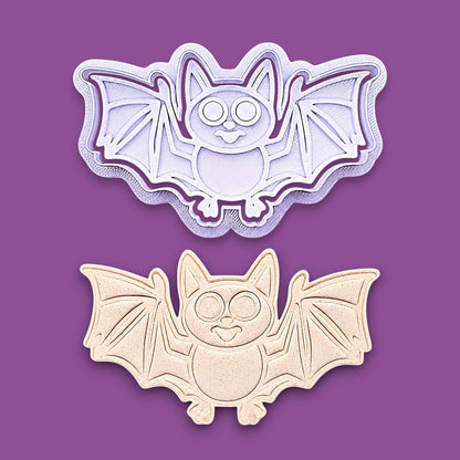 Bat cookie cutter with matching stamps and dough cutout with bat design pressed by cutter and stamp set, showing detailed lines - great for easy Halloween cookie decorating without icing.