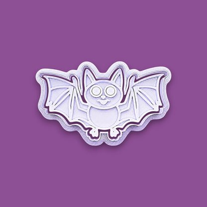 Halloween bat shaped cookie cutter and stamp shown on a purple background.