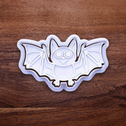 Bat-shaped Halloween cookie cutter on a wooden surface