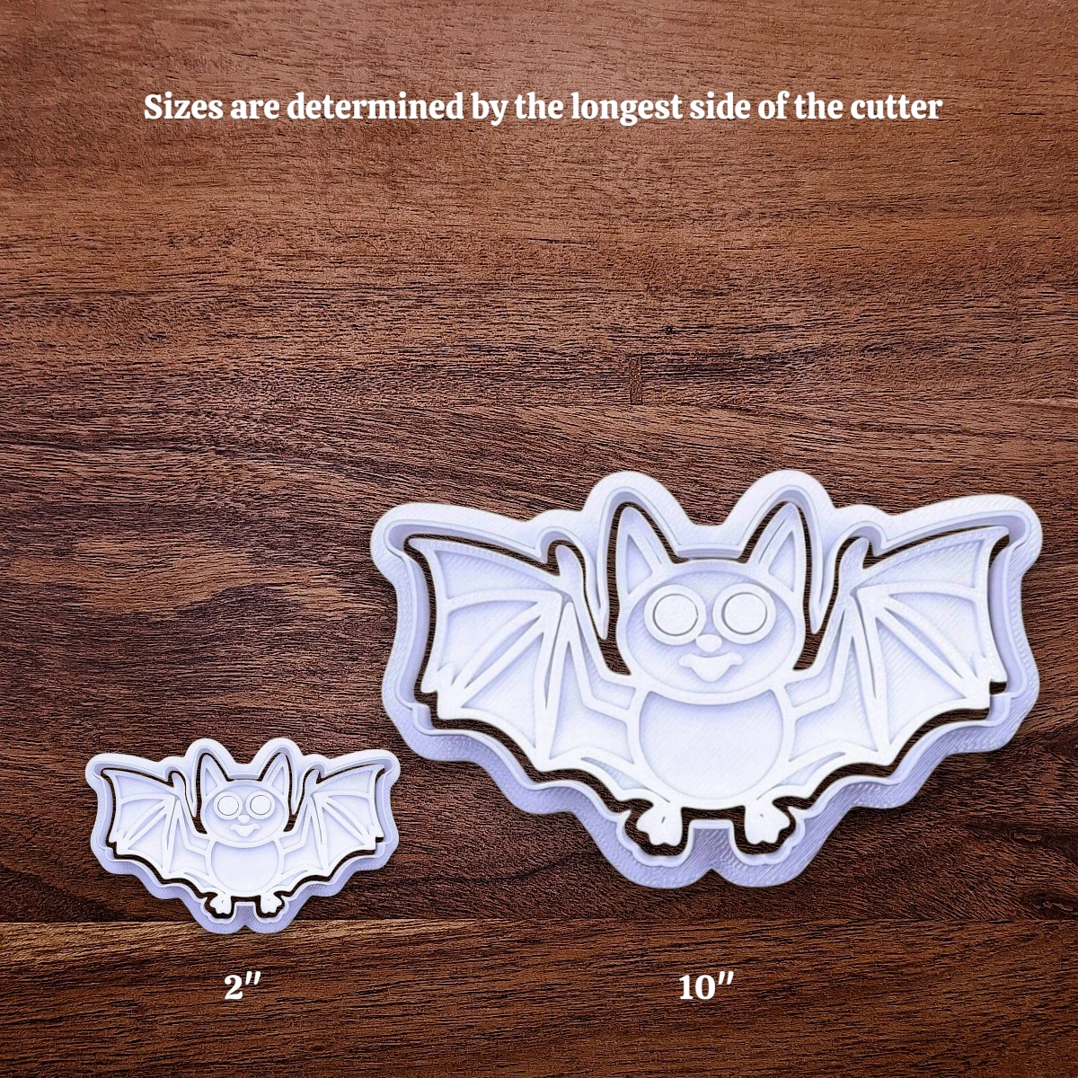 Halloween bat cookie cutters side by side to illustrate how sizing from 2 inches to 10 inches works.