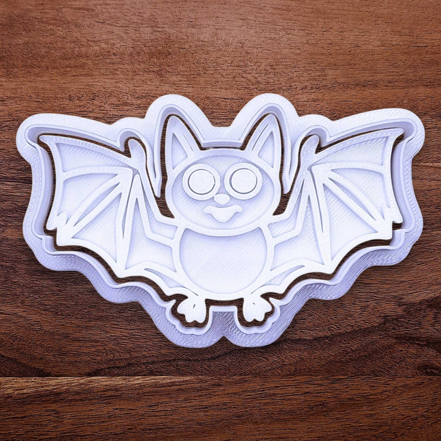 Close-up of bat cookie cutter with matching stamp, perfect for spooky Halloween cookies, fondant crafts, and gothic-themed baking projects.