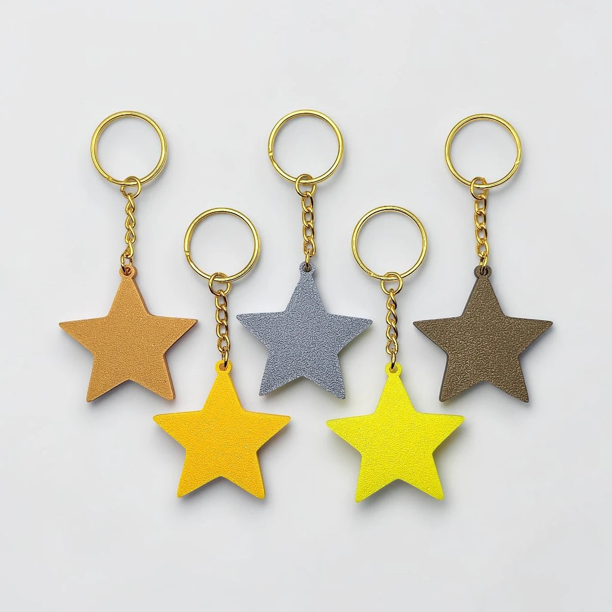 Handmade and customizable star keychains in various colors, made from eco PLA plastic, ideal for classroom prizes, rewards, events, kids, and party favors.