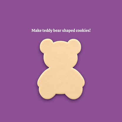 A single teddy bear-shaped cookie centered on a solid purple background, with the text 'Make teddy bear shaped cookies!' above it.