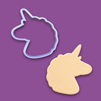 A unicorn-shaped cookie cutter outline and a matching cutout cookie shown on a solid purple background.
