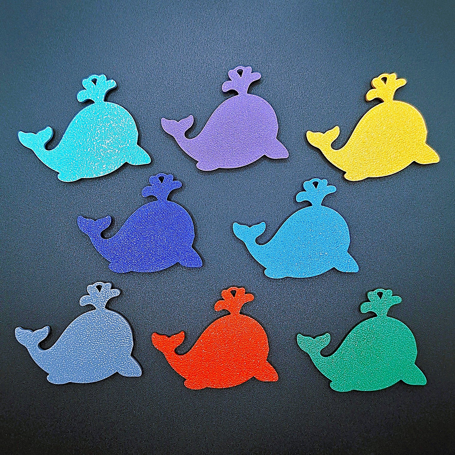 Back view of 8 whale keychains in assorted colors, showcasing handcrafted marine animal charm details and sustainable PLA design.