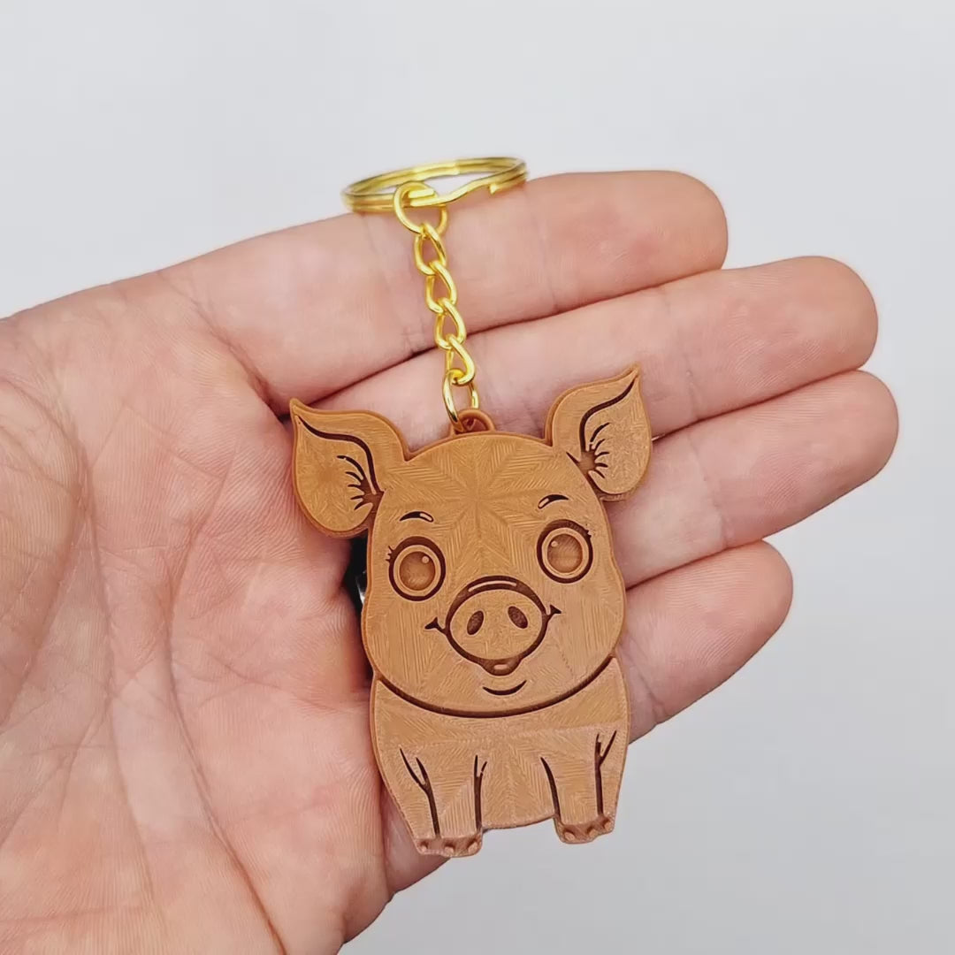 Video showing a brown pig keychains with gold keyring, ideal for themed party favors, cute country themed bag charms, and classroom prizes.