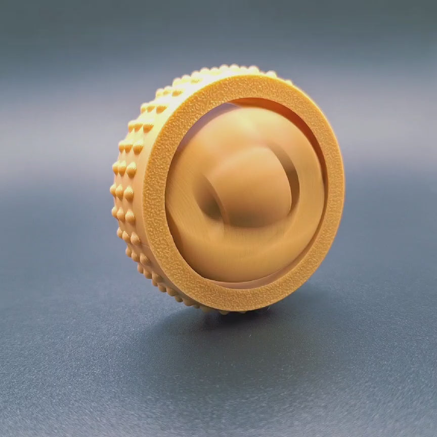 Video showing textured fidget and gyro spinner spinning in place.