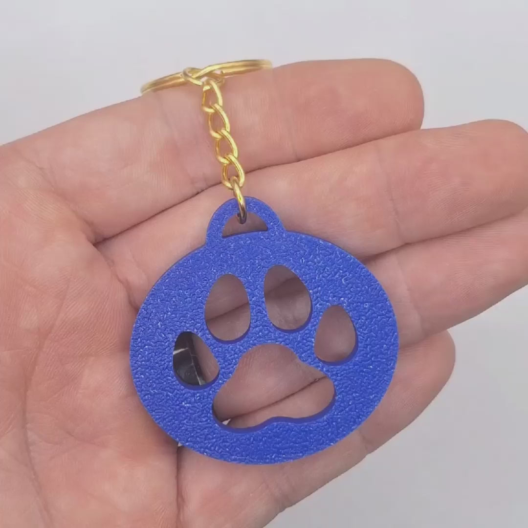 Video showing the paw print keychain, perfect for dog moms, cat lovers, rescue volunteers, shelter giveaways, and vet clinics. Handmade and customizable in 30 unique colors.